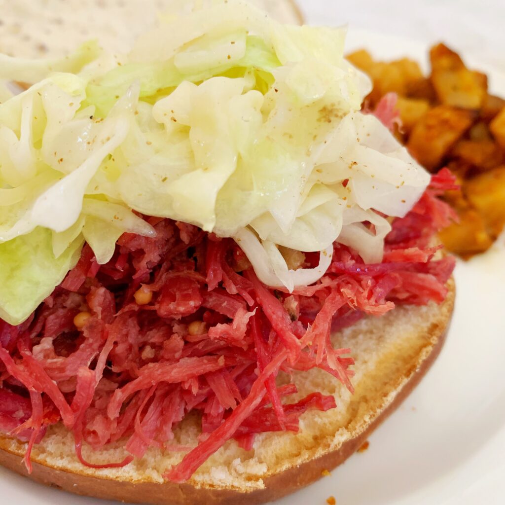 A closeup picture of corned beef and cabbage sandwich.