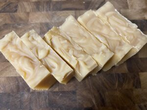 artisanal goat milk soap lined up on cutting board