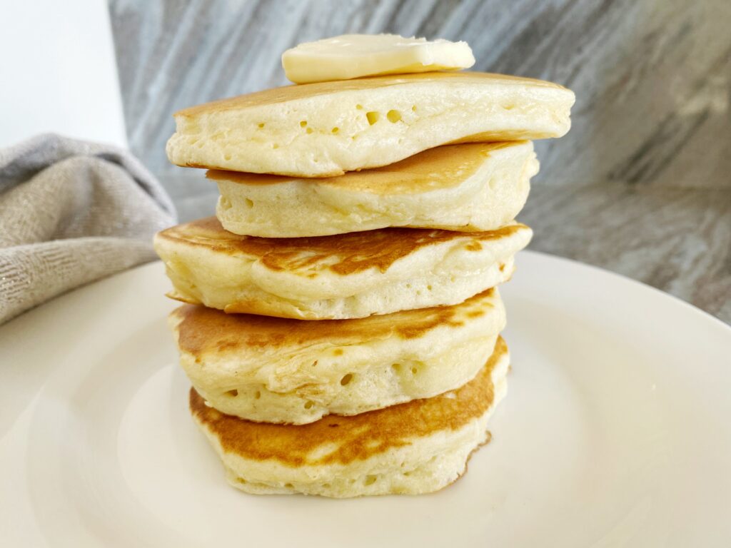 A stack of puffy pancakes before being drizzled in syrup