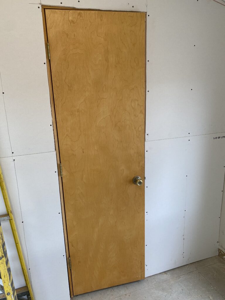 A picture of a 90s yellow tacky door before it was replaced with a salvaged door