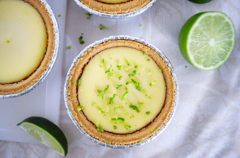 A picture of lime and goat cheese individual cheesecakes with lime zest on top
