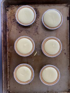 A picture of individual cheesecakes right out of the oven
