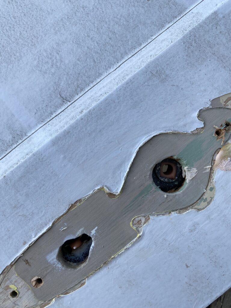 A picture of a keyhole that shows the different coats of paint colors on the door