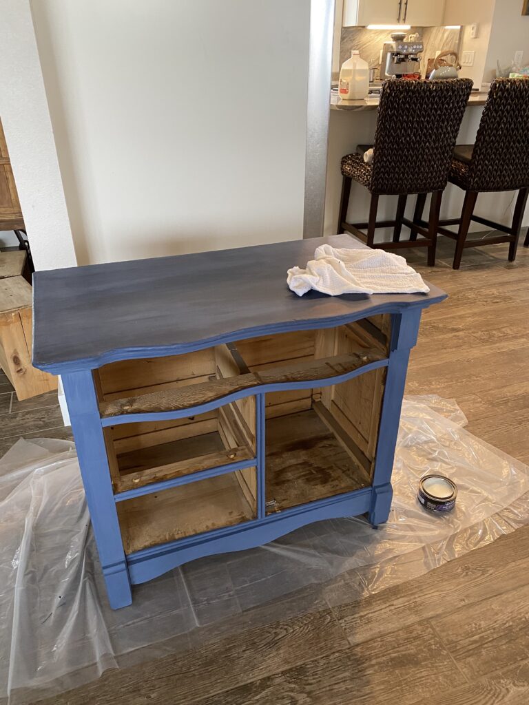 A picture of a coastal blue painted dresser that has been freshly waxed before the drawers and doors have been added. 