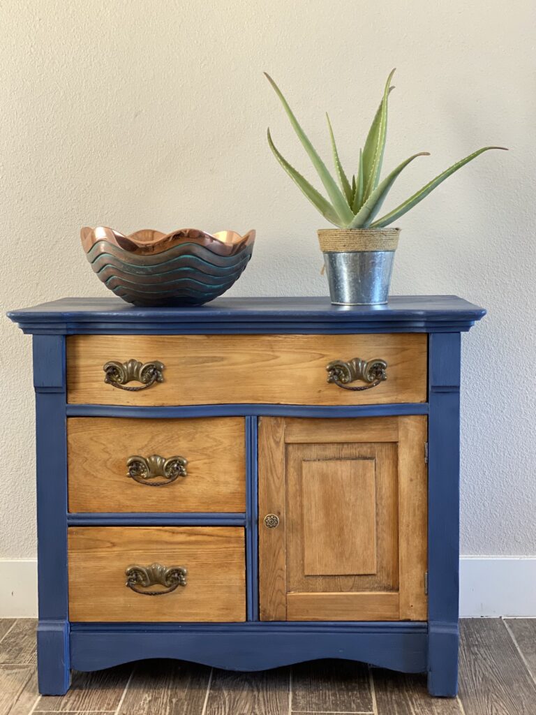 A picture of a dresser that has been redone with a painted and raw wood refinishing style. 